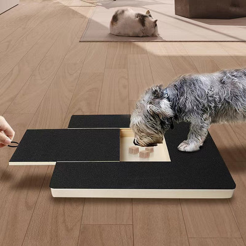 Dog filing its nails on the PawFile scratch board while taking treats from the built-in treat box